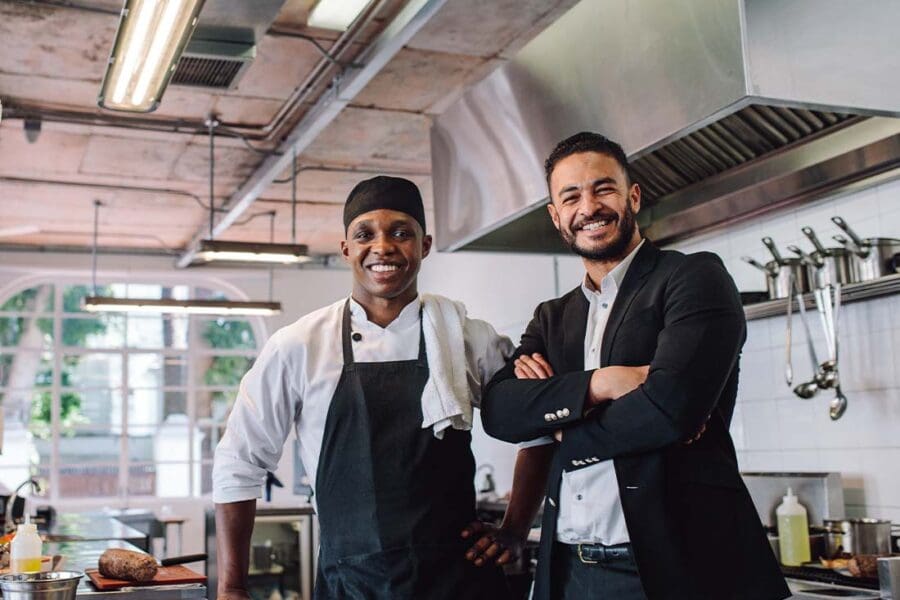 Restaurant Insurance - Portrait of a Happy Restaurant Owner and Chef in the Kitchen of a Brand New Establishment